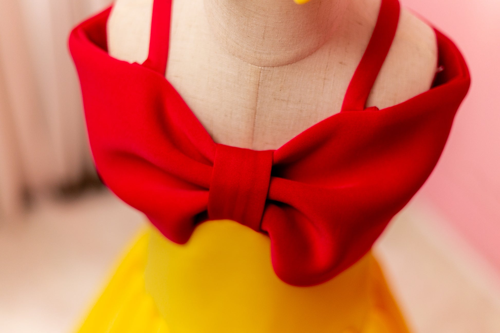 Fuchsia pink and yellow big bow dress displayed on design stand