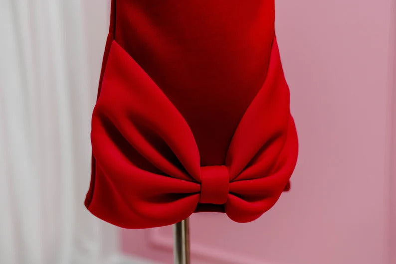 Lower half of red dress showing block bow