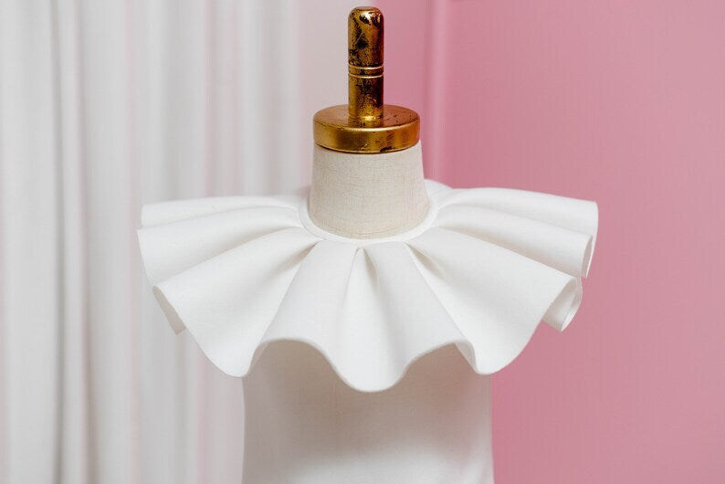 ruffle collar of white dress displayed on fashion stand