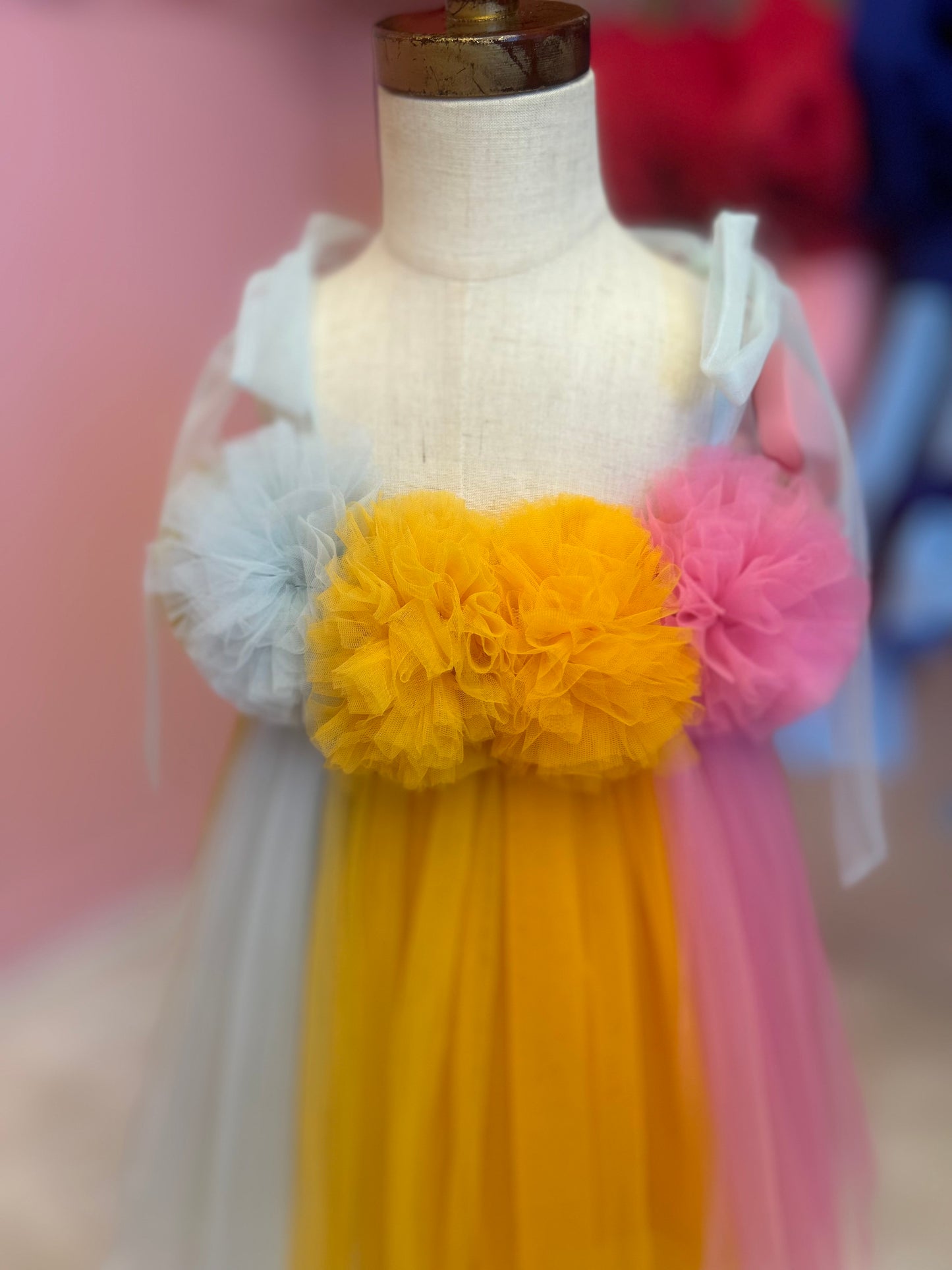 close up of multi-coloured dreamy tulle dress for little girl, displayed on fashion stand