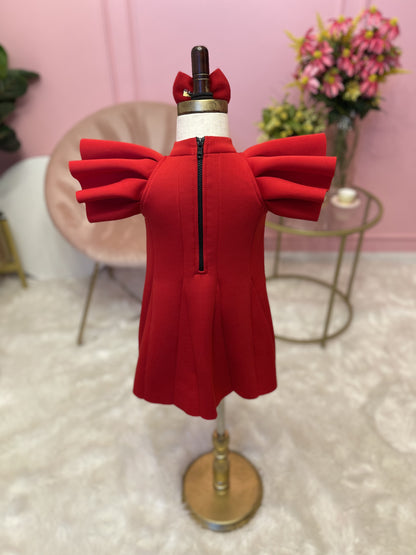 back view of Red ruffle sleeve dress with matching hair bow displayed on fashion stand