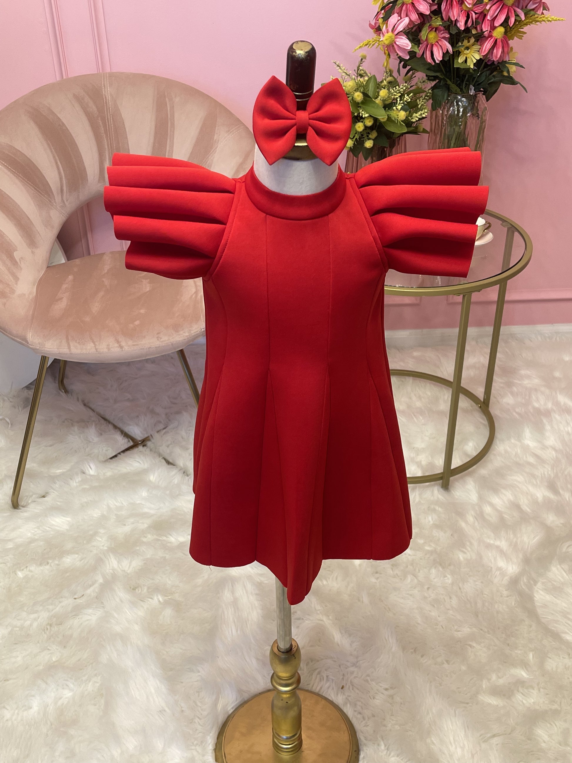 Red ruffle sleeve dress with matching hair bow displayed on fashion stand