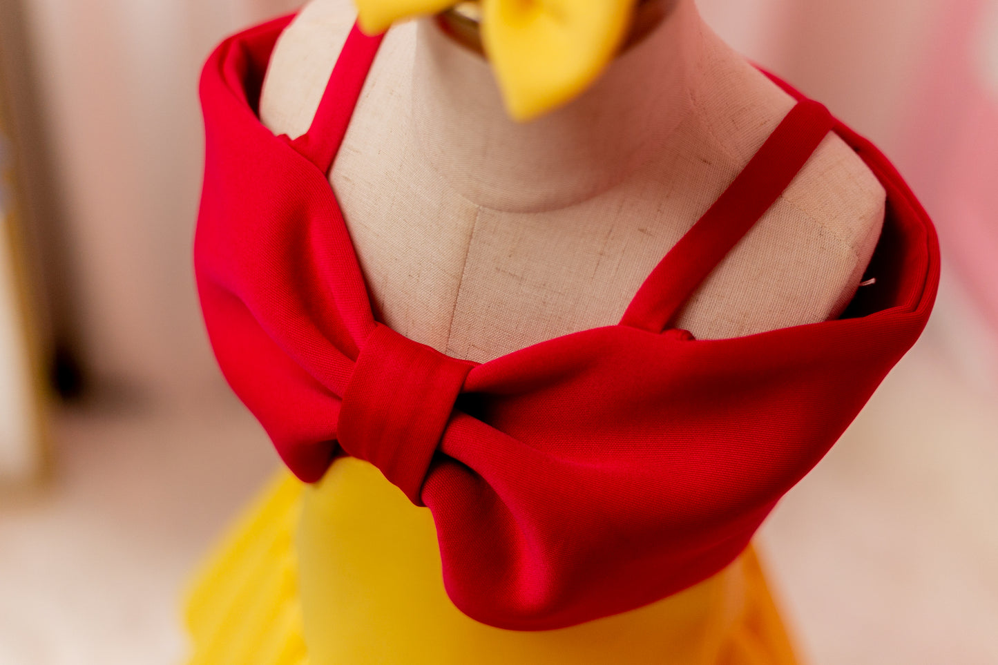 Fuchsia pink and yellow big bow dress displayed on design stand