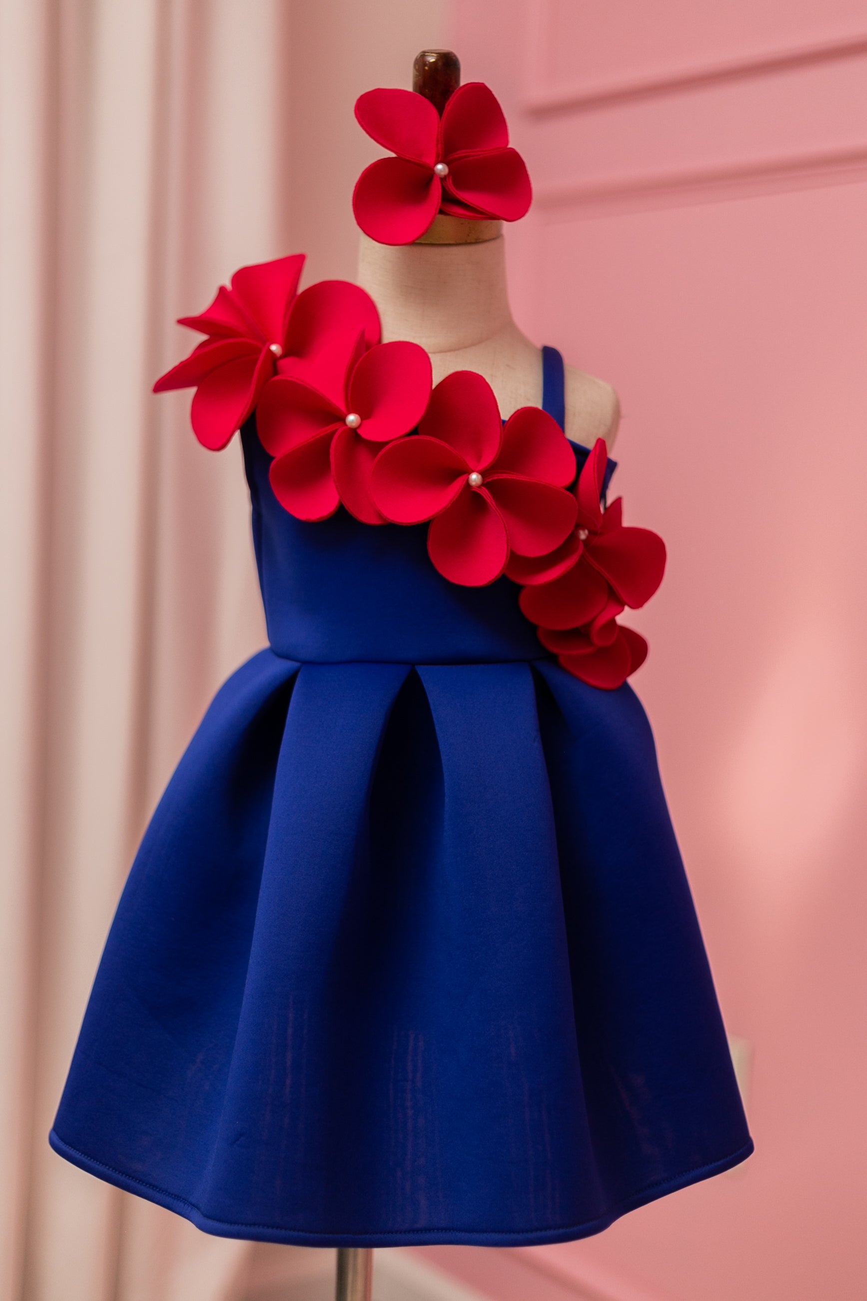 One shoulder blue and fuchsia pink flower dress displayed on fashion stand