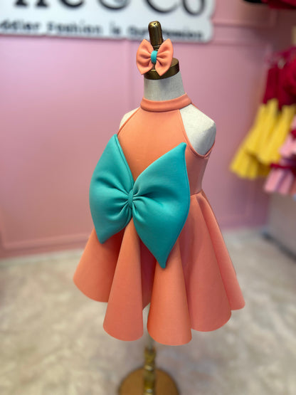 sideview of peach and mint sweet bow dress with matching head piece displayed on fashion stand