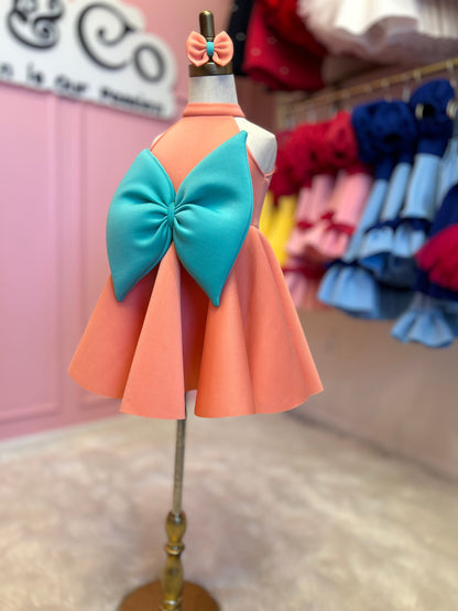 sideview of peach and mint sweet bow dress with matching head piece displayed on fashion stand