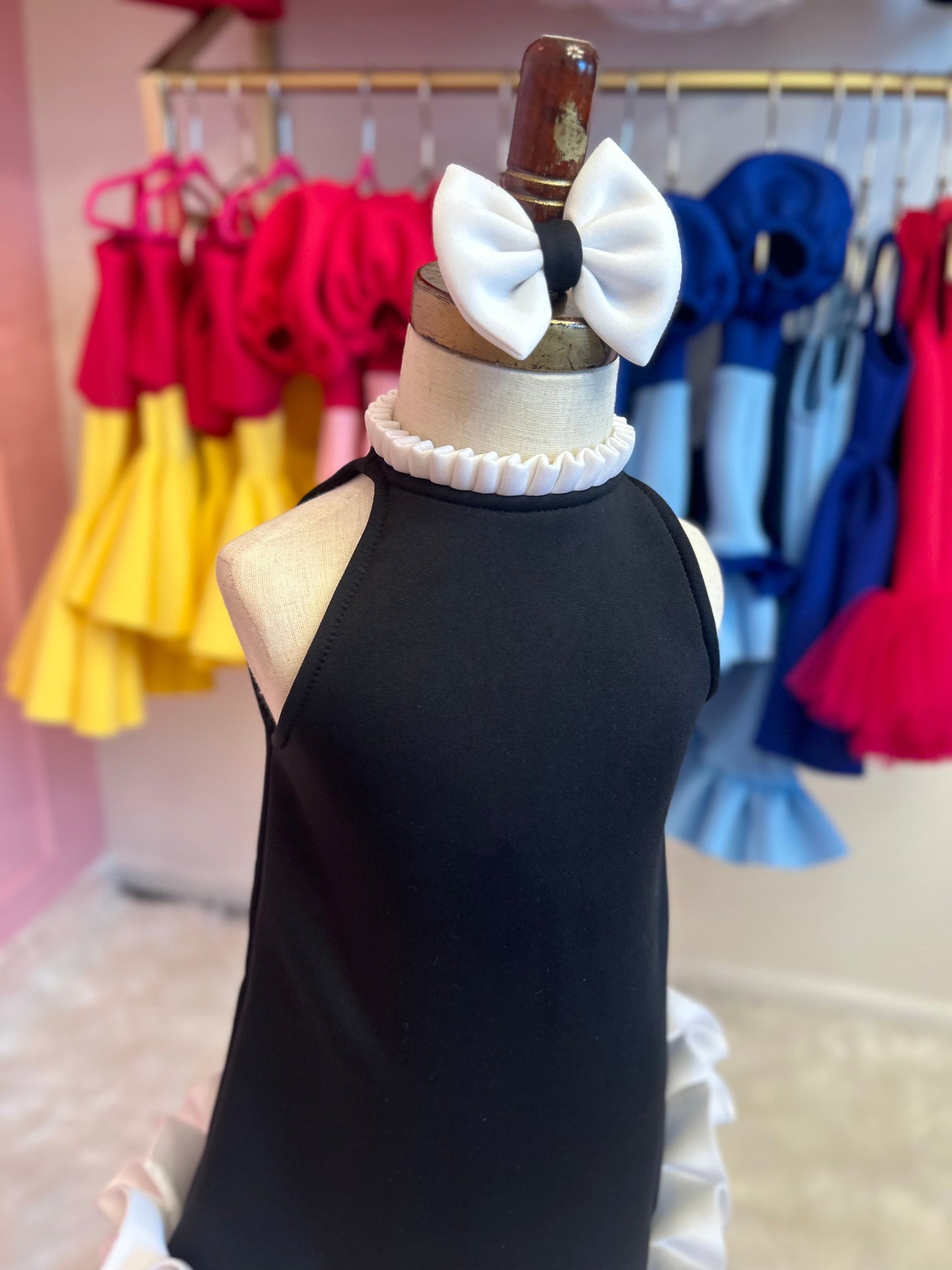 close up of Black dress with neckline ruffle, displayed on fashion stand