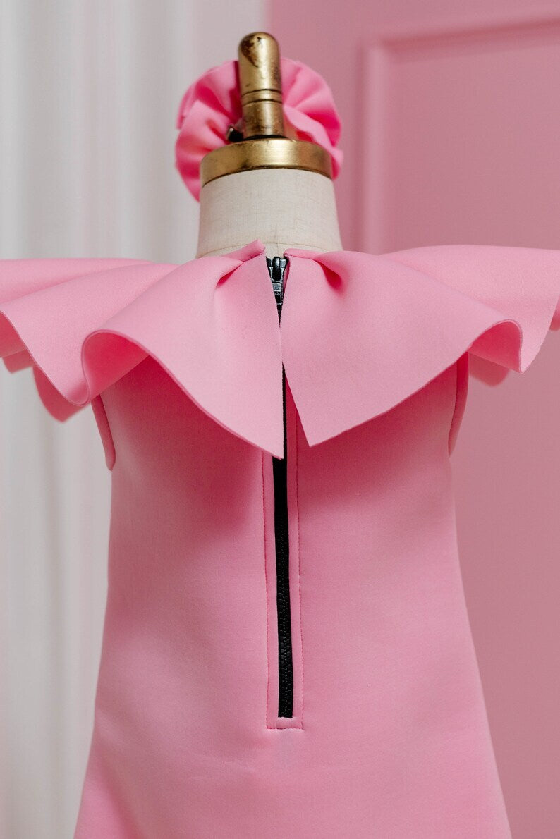 rear view of pink ruffled collar dress displayed on fashion stand