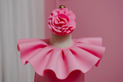 close up of ruffled collar and matching head piece of pink dress