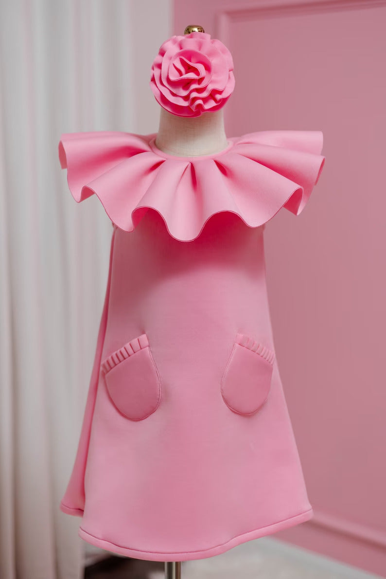 Pink ruffle collar dress with matching head piece displayed on fashion stand